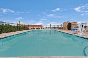 Una piscina al aire libre de temporada, sombrillas, tumbonas