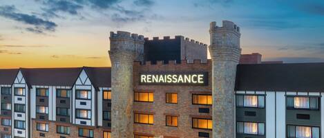 Hotel Renaissance com fachada de pedra, diversas janelas e uma placa chamativa.