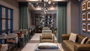 A modern interior with a seating area, a bar, and a bookshelf. - Renaissance Framingham Hotel & Conference Center (Framingham)