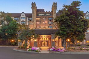 A Renaissance hotel with a prominent castle-like entrance, a flag, and a well-lit facade. - Renaissance Framingham Hotel & Conference Center (Framingham)
