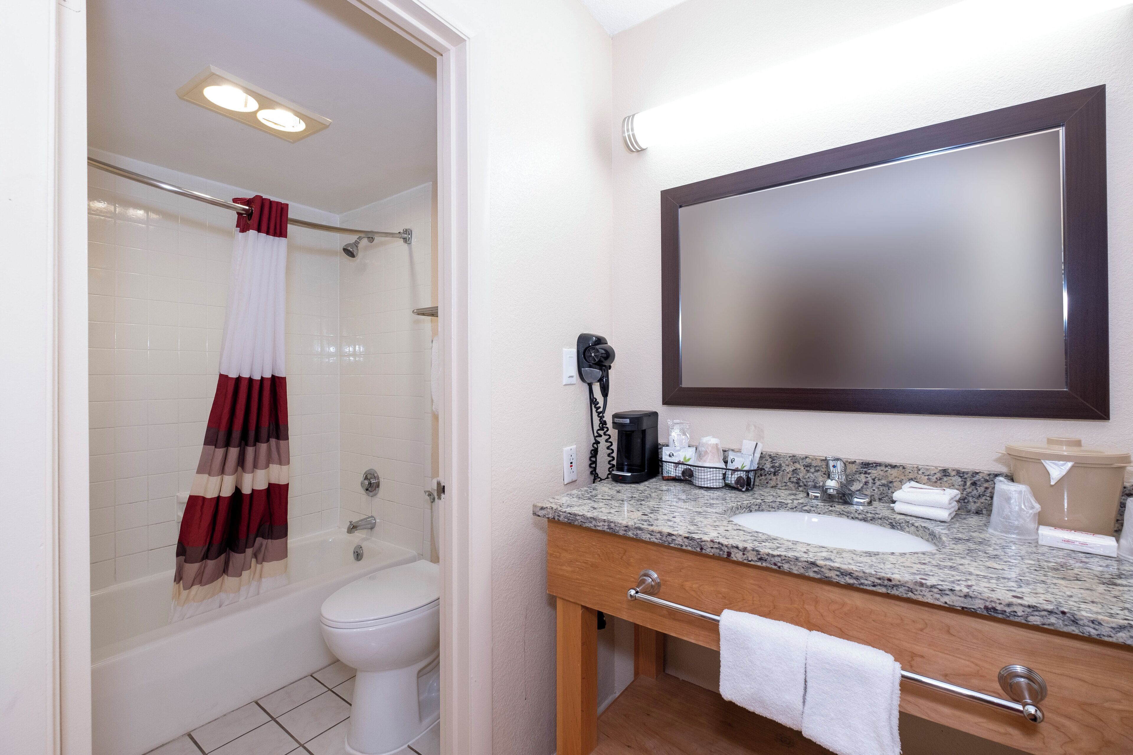 Ein Badezimmer mit Dusche, Toilette, Waschbecken und Spiegel.