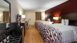 A hotel room with two beds, a desk, a chair, a television, and a door. - Red Roof Inn Knoxville North - Merchants Drive (Knoxville)
