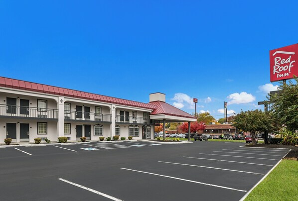 Un Red Roof Inn con estacionamiento y zona de estacionamiento techada.