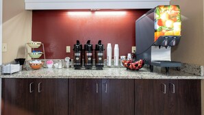A kitchen with a coffee station, a fruit bowl, and a juice dispenser. - Red Roof Inn Knoxville North - Merchants Drive (Knoxville)