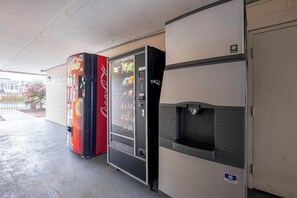 Myyntiautomaatti ja jääkaappi, jossa on juoma-annostelija.