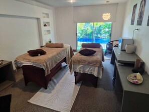 A room with two beds, a desk, a chair, and a window with a view of greenery. - Riande Aeropuerto Hotel & Casino (Tocumen)
