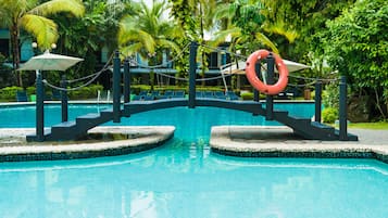 Una piscina al aire libre, camas de piscina gratis, sombrillas