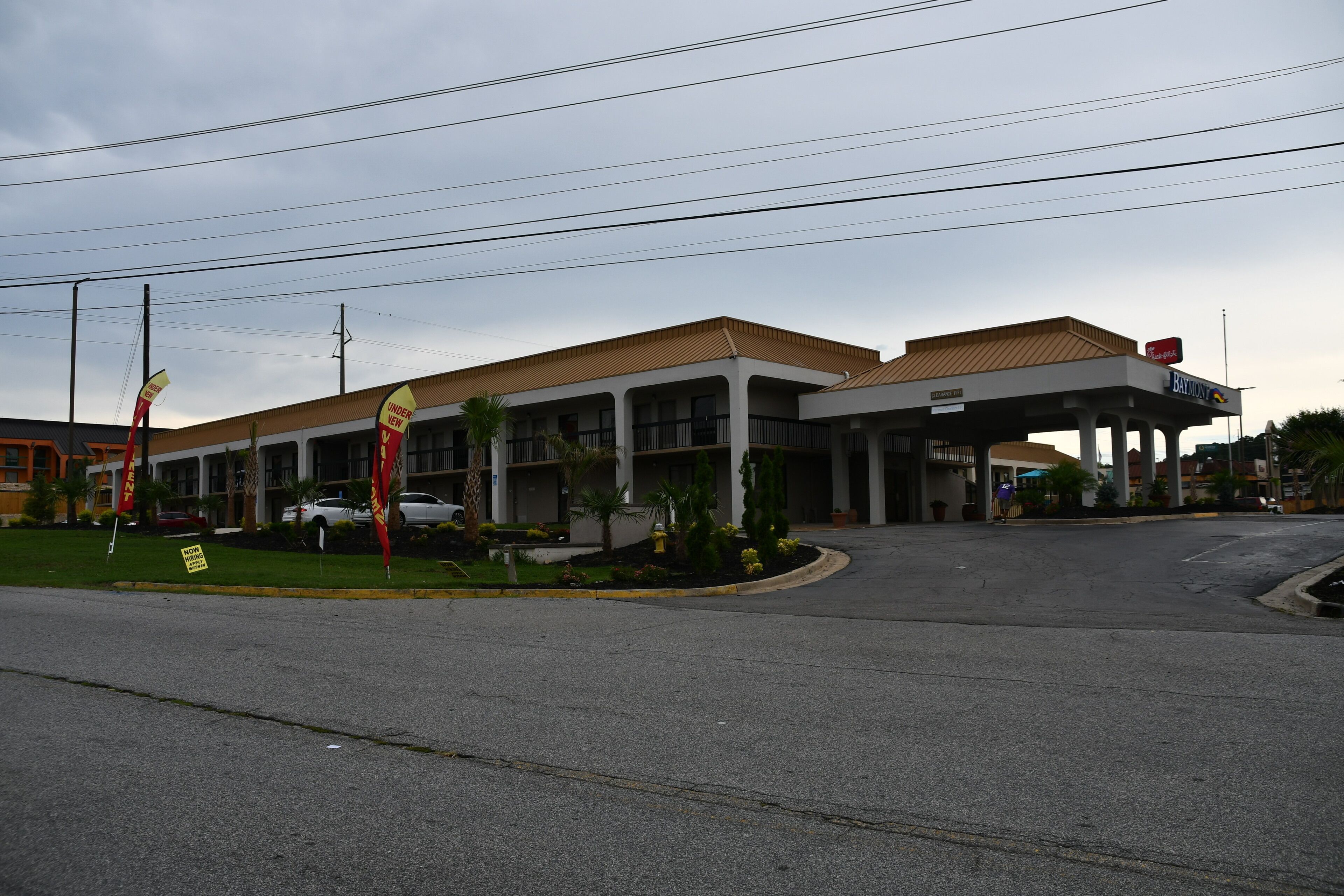 A gas station with a canopy, multiple fuel pumps, and a parking lot.