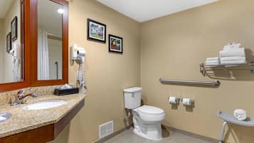 A bathroom with a sink, mirror, toilet, and towel rack.