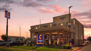 Un hotel Comfort Inn con diseño moderno, que cuenta con una entrada destacada y un estacionamiento.