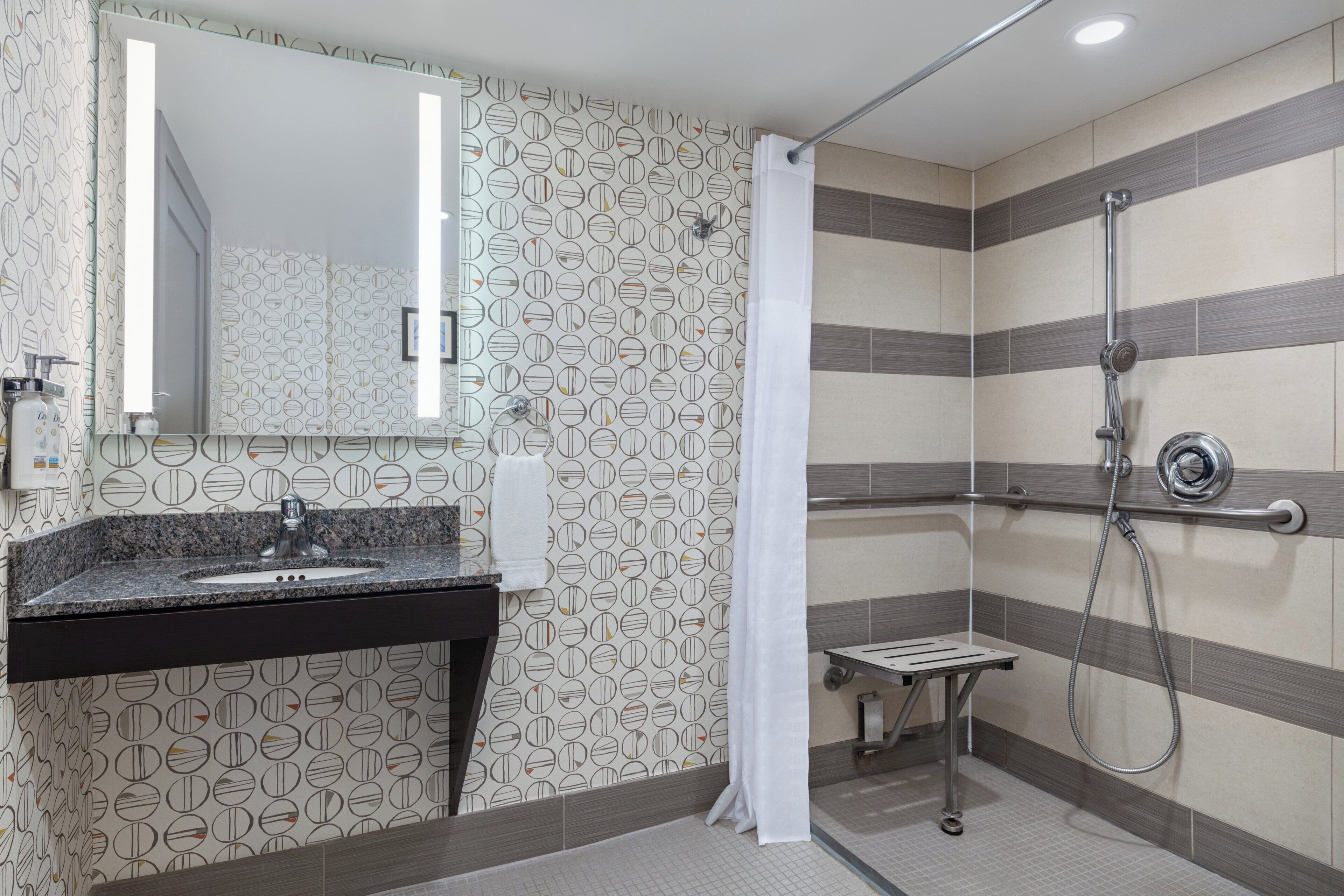 Une salle de bain avec une douche, un lavabo et un miroir.