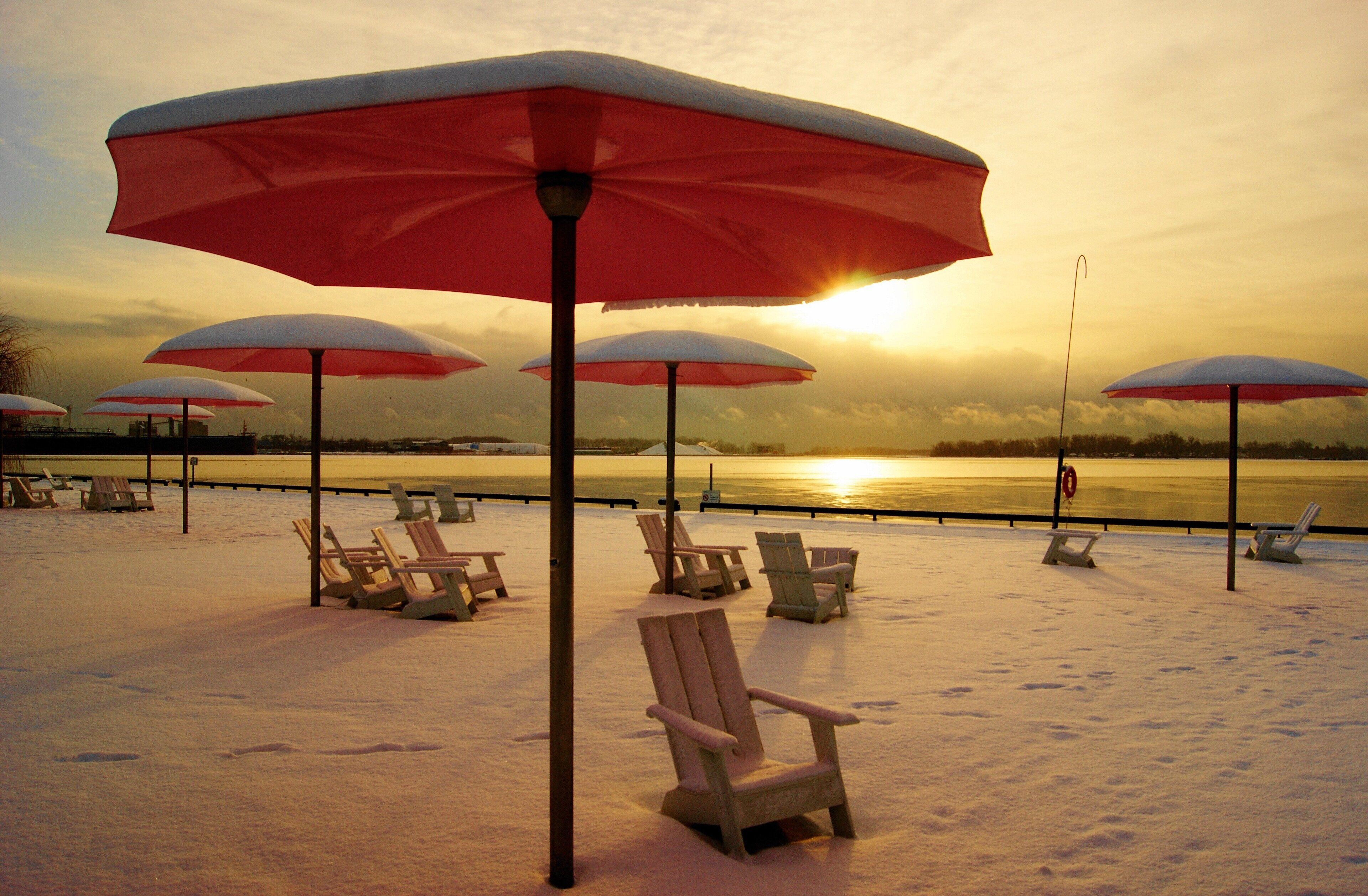 A beach with several sun umbrellas and lounge chairs.