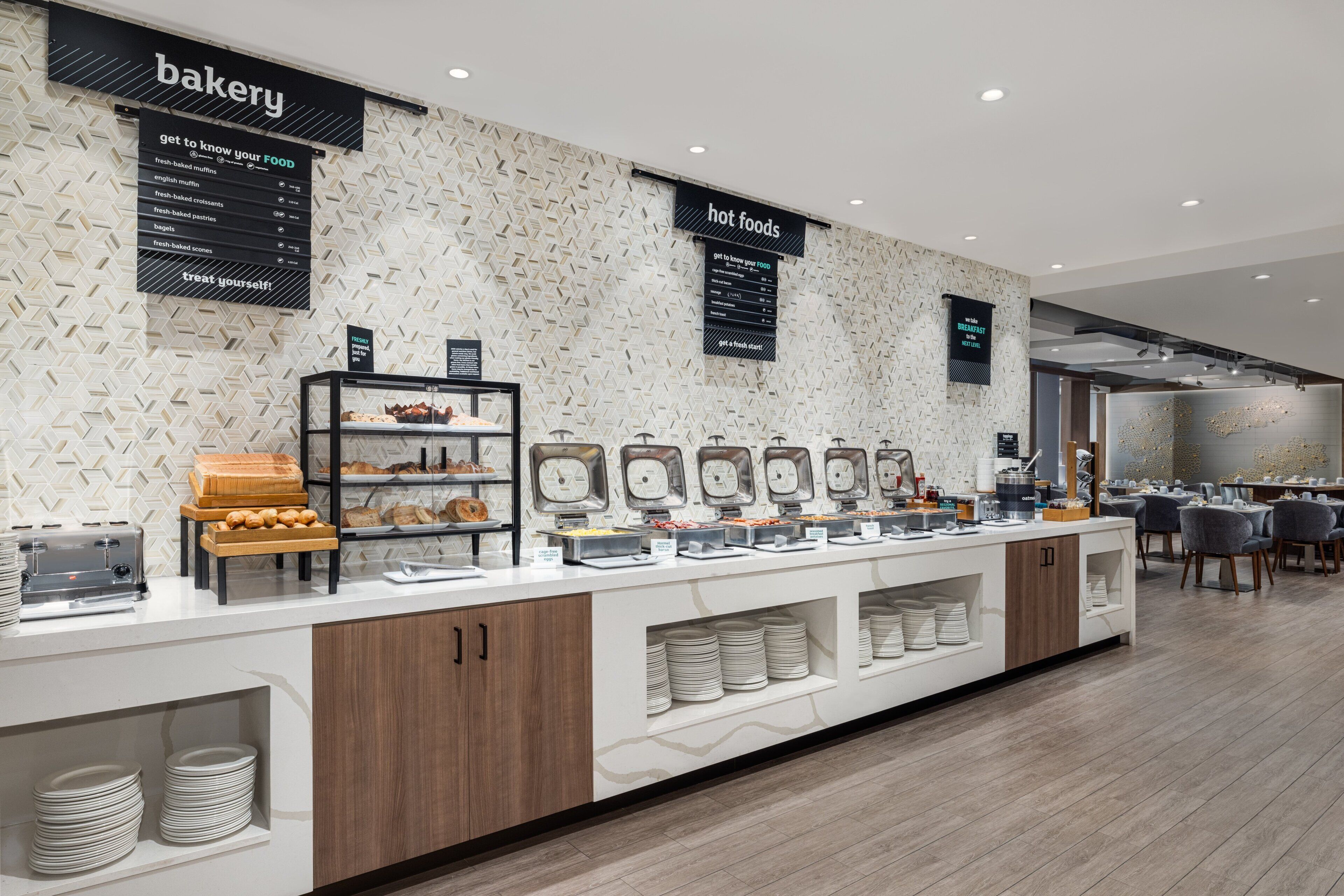 Ein moderner Verkaufstresen einer Bäckerei mit verschiedenen Backwaren und einer Kaffeestation.