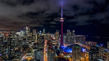 Un paisaje urbano nocturno con una torre destacada y edificios urbanos densos.