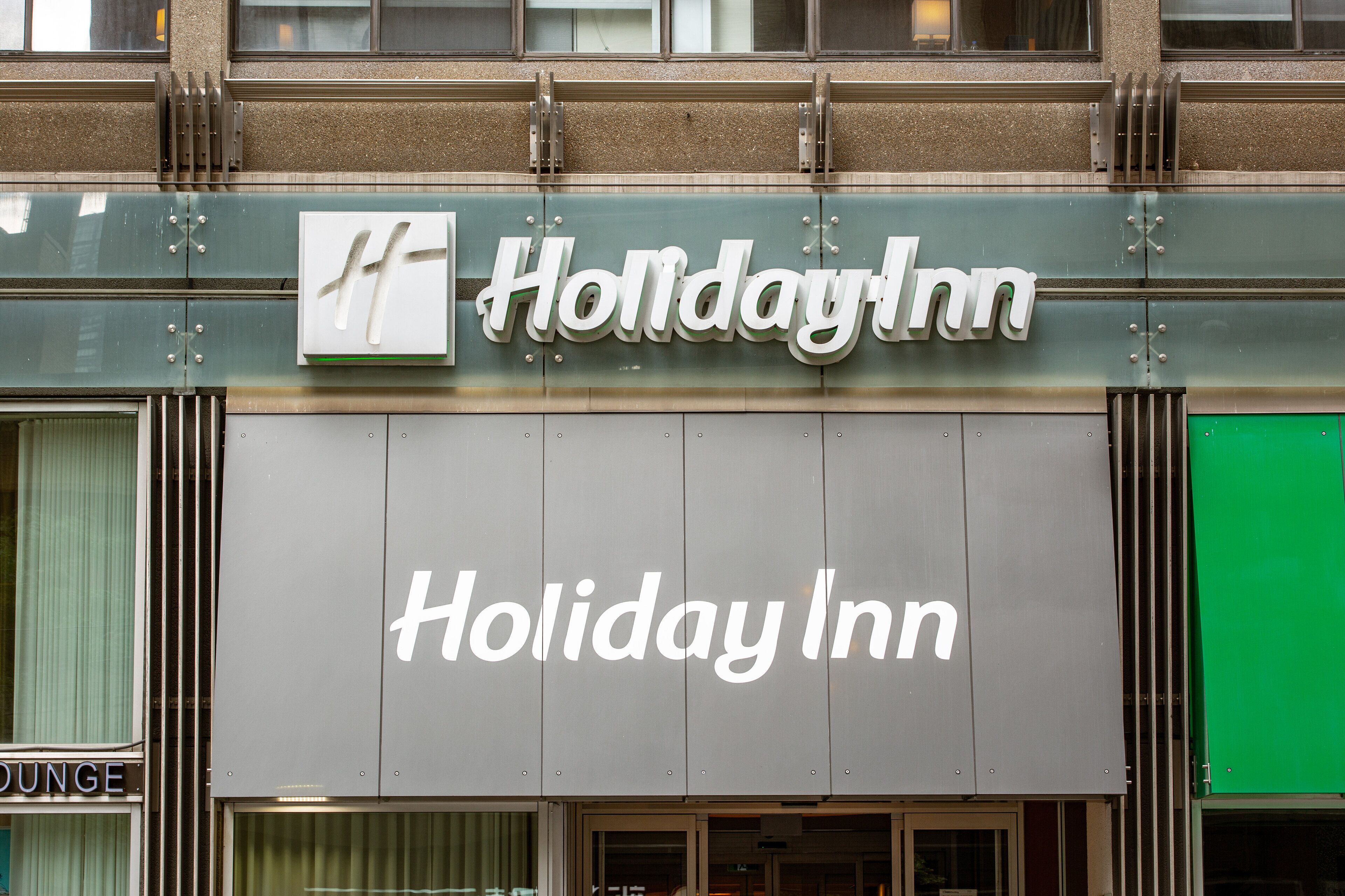 Señal de Holiday Inn con una combinación de colores verde y blanco.