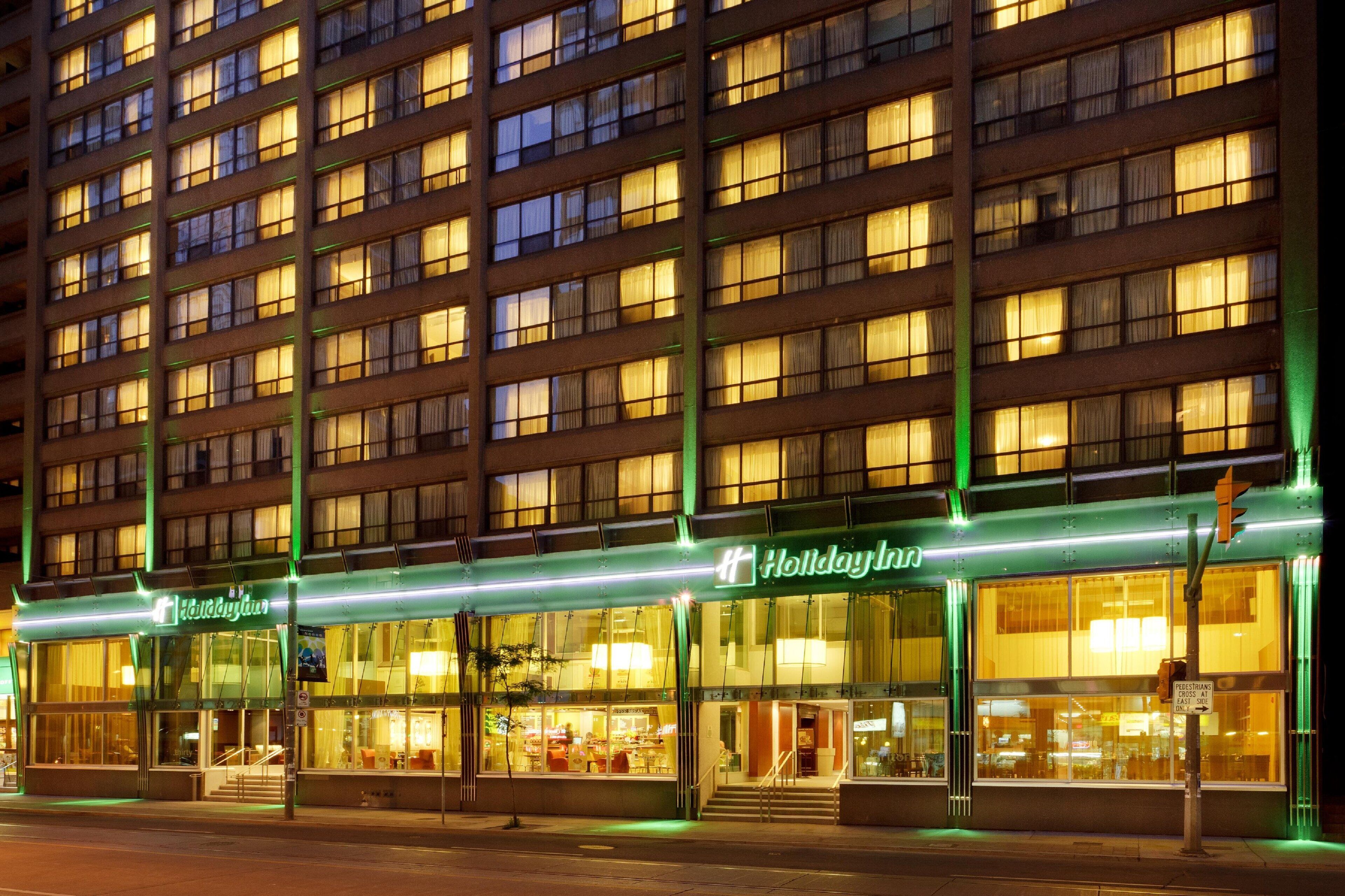 Ein mehrstöckiges Hotel mit beleuchteter Beschilderung und großen Fenstern.