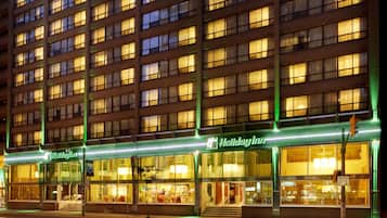 A multi-story hotel with illuminated signage and large windows.