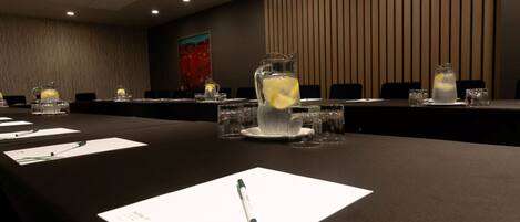 Ein Konferenzraum mit einem langen Tisch, Namensschildern und einer Wasserkanne mit Zitronenscheiben.