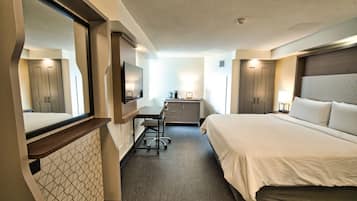 Une chambre d’hôtel équipée d’un lit, d’un bureau, d’une chaise et d’une armoire.