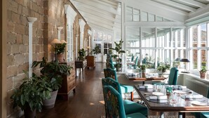 A spacious, well-lit room with wooden floors, large windows, and a brick wall. - The Devonshire Arms Hotel (Skipton)
