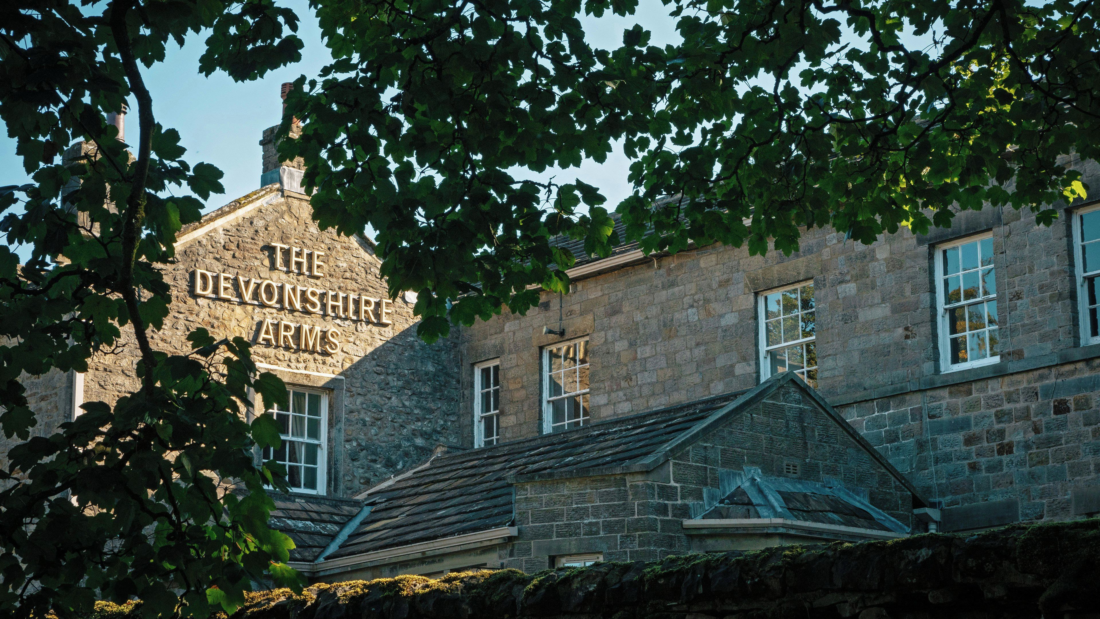 Un edificio de piedra con un letrero que dice 'The Devonshire Arms'.