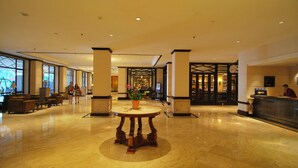 A spacious lobby with a marble floor, a central round table, and a reception desk. - Le Grandeur Balikpapan (Balikpapan)