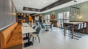 A spacious restaurant with high ceilings, recessed lighting, and a mix of seating options including booths and tables.