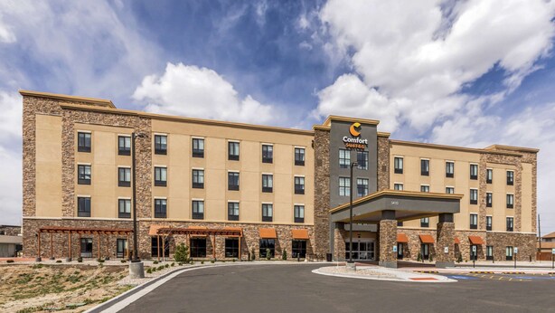 A Comfort Suites hotel with a stone facade, multiple floors, and a covered entrance.
