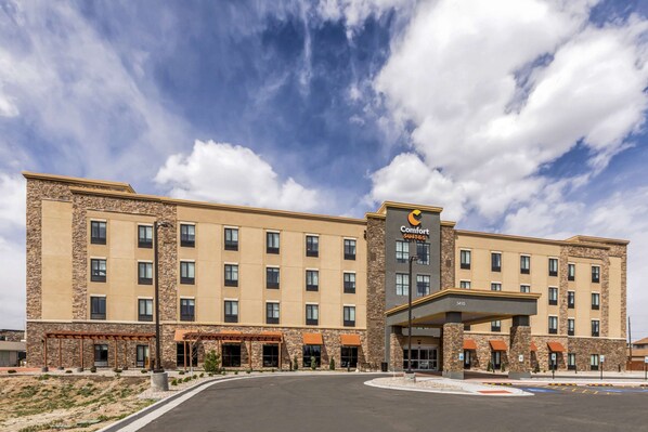 A Comfort Suites hotel with a stone facade, multiple floors, and a covered entrance.