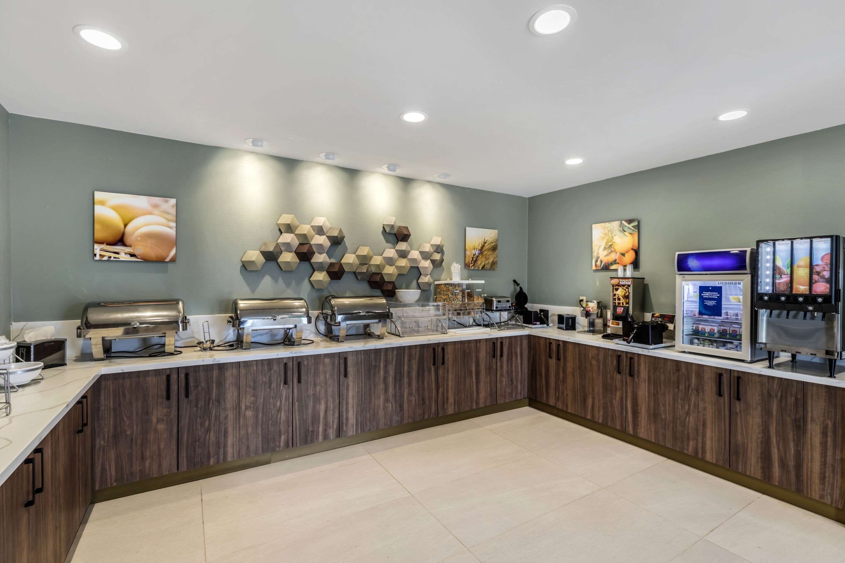 A modern breakfast bar with a wooden counter, various food dispensers, and wall art.