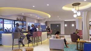 Un área de lounge moderna con bar, asientos y mostrador de recepción.