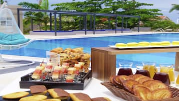 Una piscina al aire libre, sombrillas, sillones reclinables de piscina