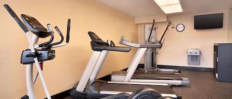A fitness room with treadmills and elliptical machines.