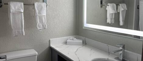 Ein modernes Badezimmer mit Toilette, Waschbecken und Handtuchhalter.