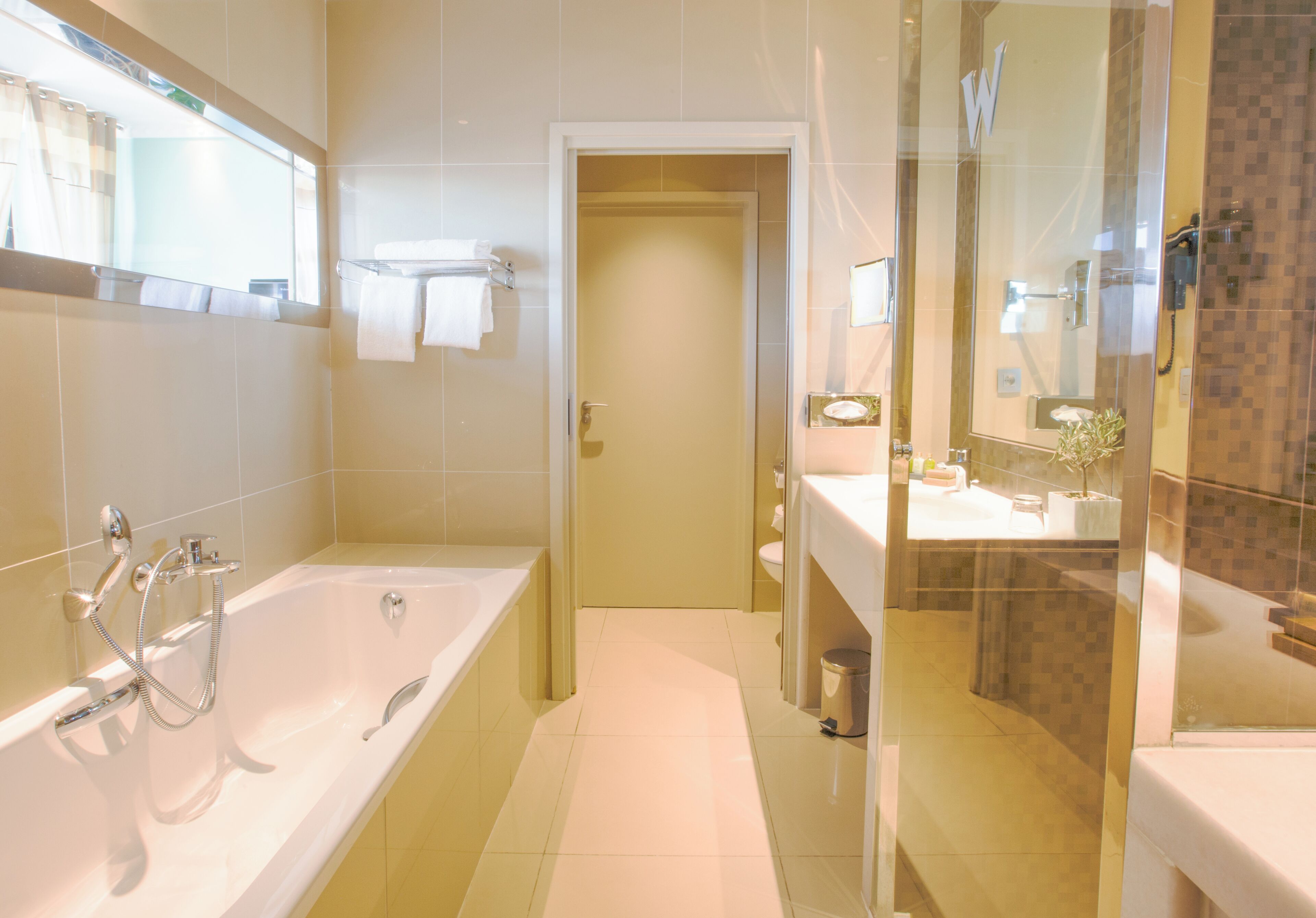 A modern bathroom with a bathtub, a shower, and a sink.