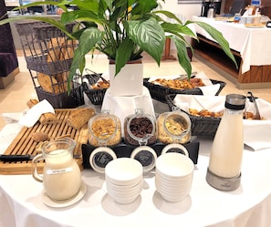A buffet table with various food items, a plant, and a thermos. - Westminster Hotel & Spa Nice (Nice)