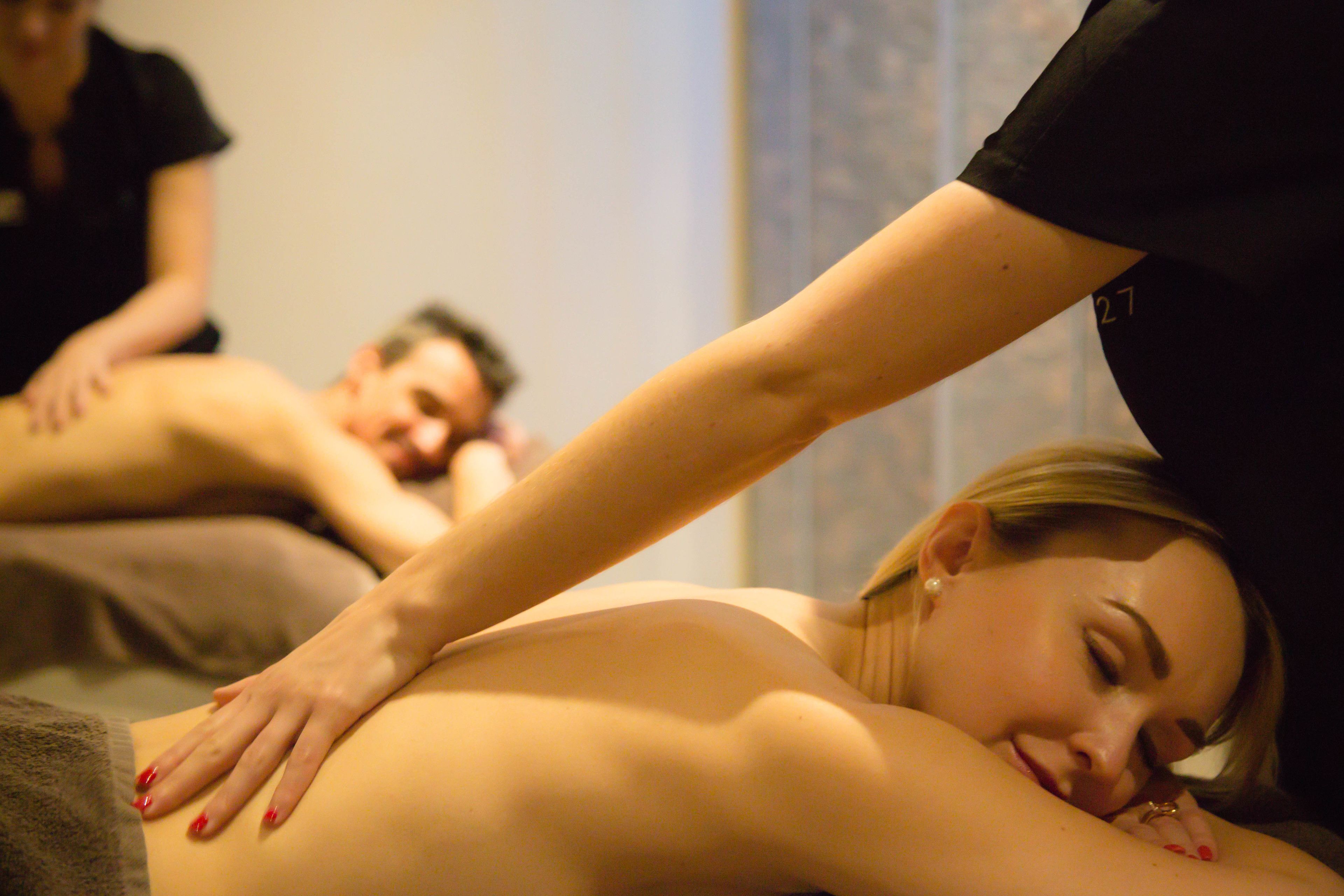 A massage therapy session in progress with a therapist attending to a client.