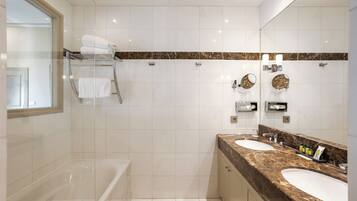 Un baño moderno con una bañera, dos lavamanos, una cabina de ducha de vidrio y encimera de mármol.