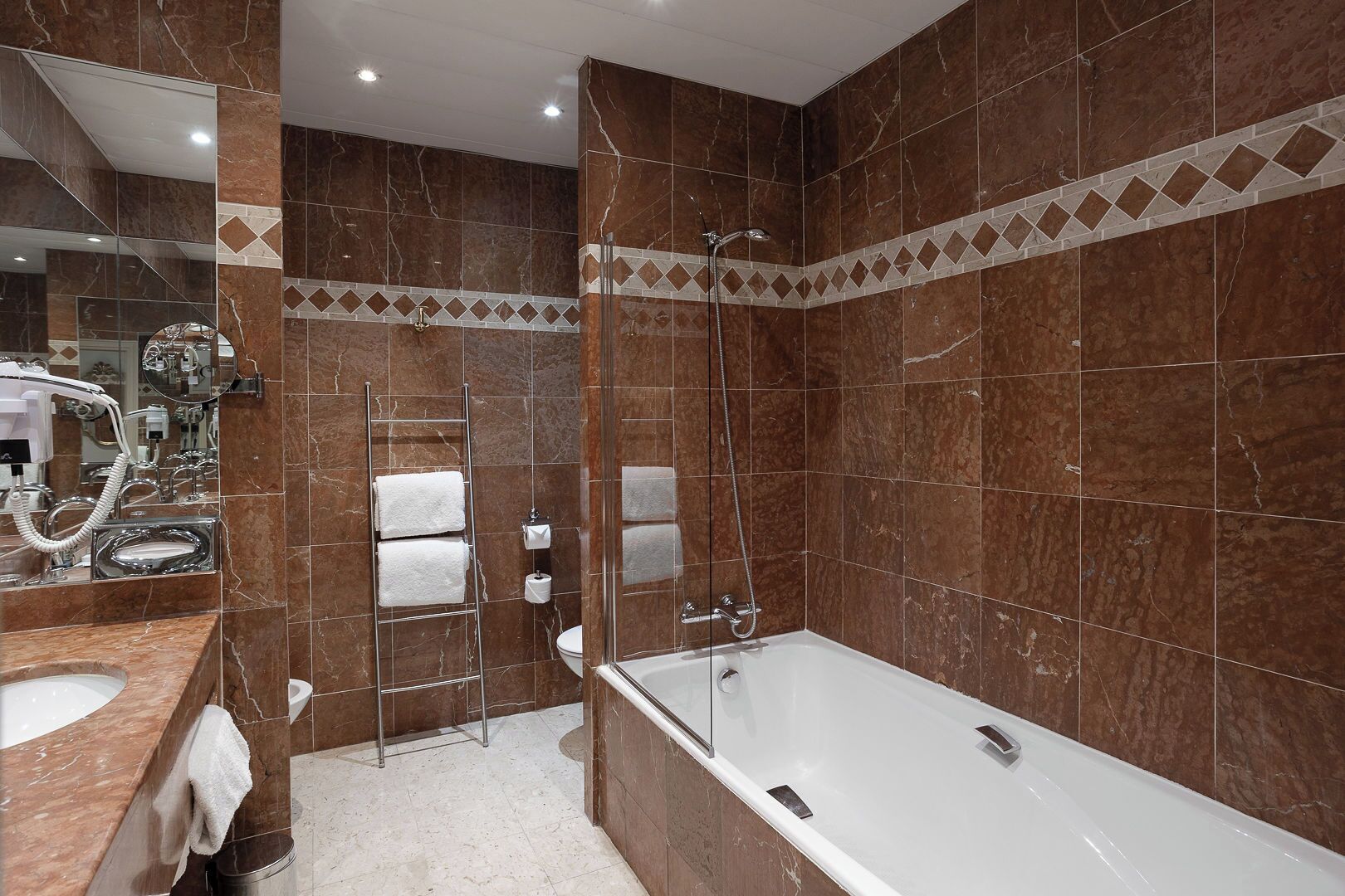 A modern bathroom with a large bathtub, a glass-enclosed shower, and a vanity with a mirror and sink.