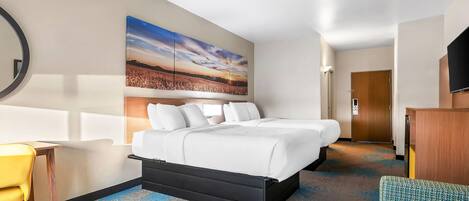 A hotel room with a bed, a desk, a chair, a television, and a large painting on the wall.