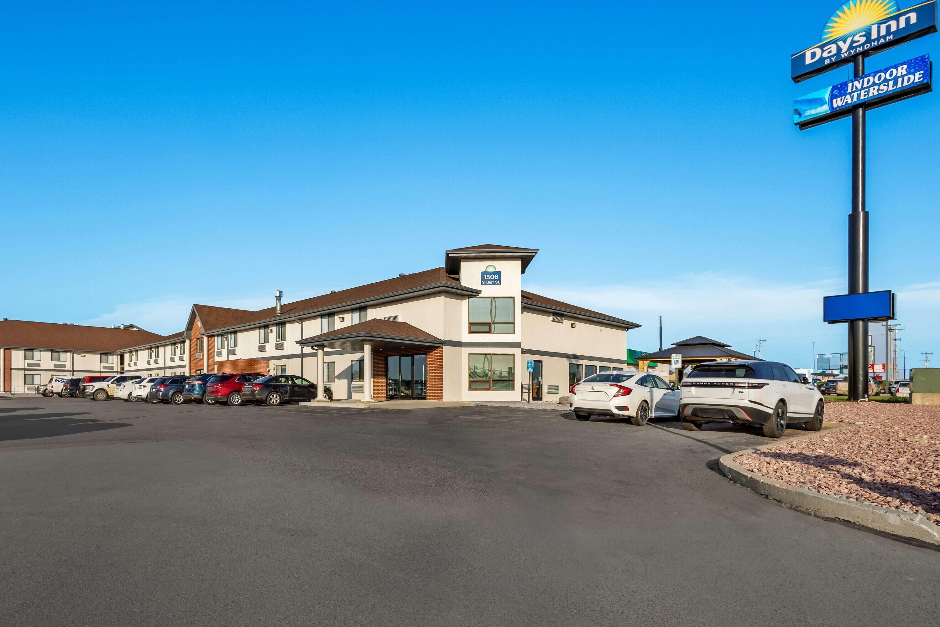 Un hôtel Days Inn by Wyndham doté d’un parking et de plusieurs voitures.