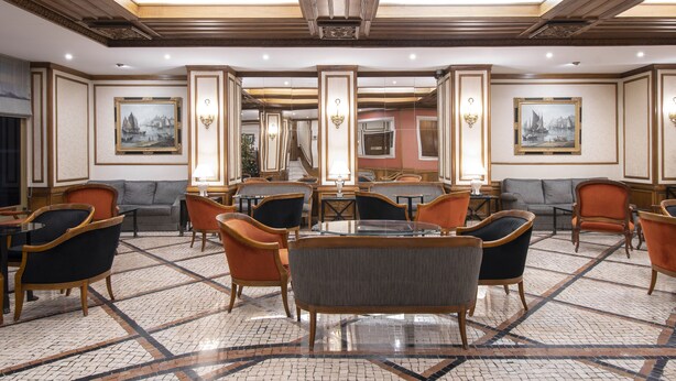 A spacious lobby with a central seating area, multiple sofas, and tables. - SANA Rex Hotel (Lisbon)