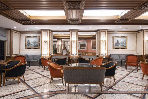 A spacious lobby with a central seating area, multiple sofas, and tables. - SANA Rex Hotel (Lisbon)