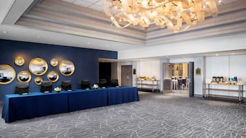 A conference room with a long table, multiple chairs, and a chandelier.