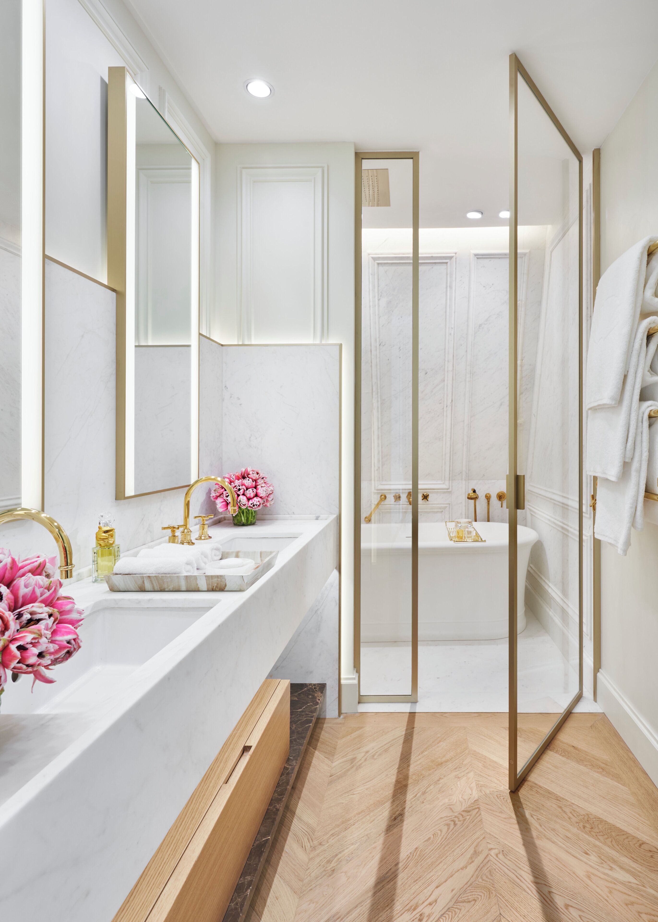 Un baño moderno con un espejo grande, lavamanos dobles, bañera y zona de ducha.
