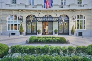 A grand building with a symmetrical facade, large arched windows, and a central entrance with ornate black metal gates. - Mandarin Oriental Ritz, Madrid (Madrid)