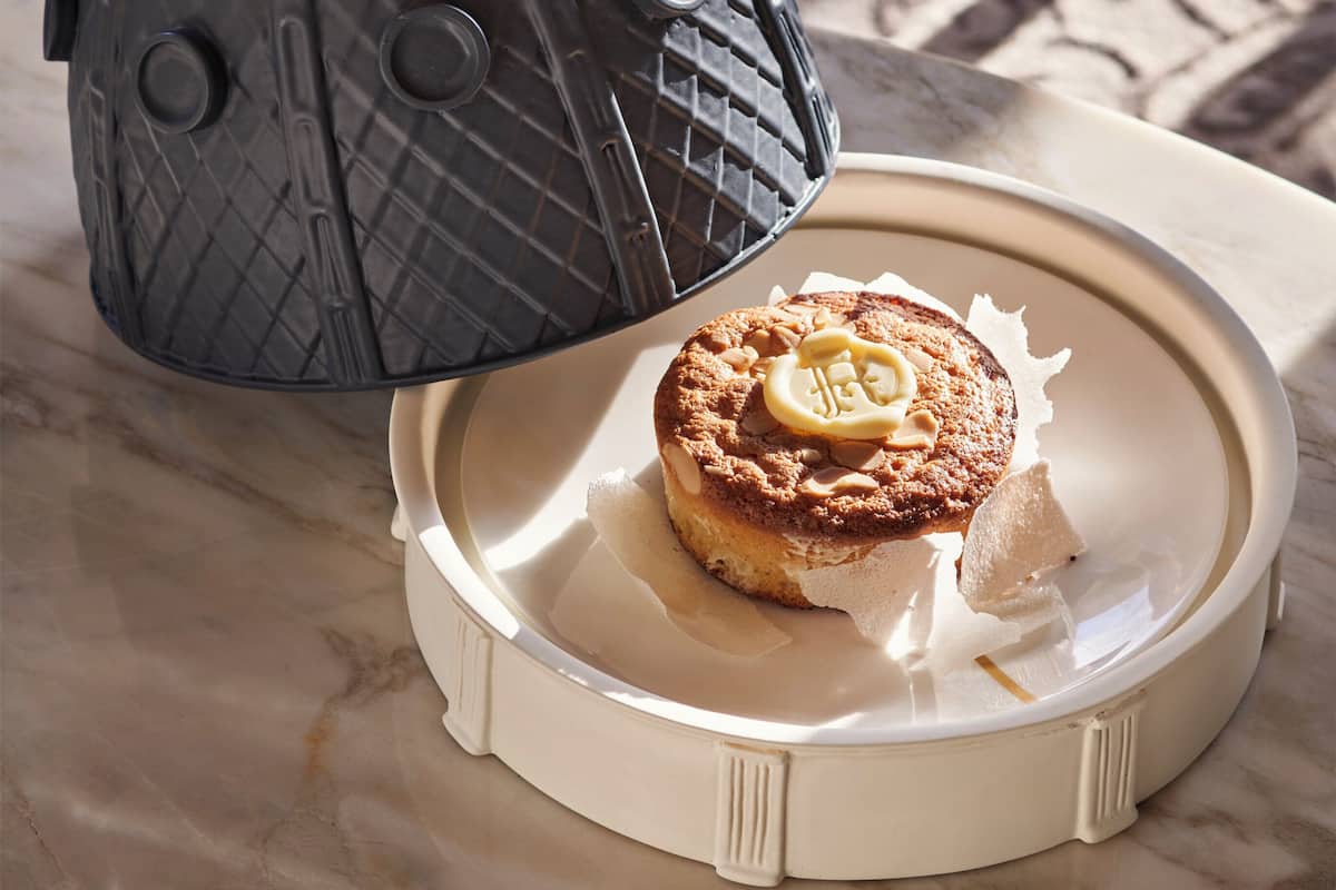 A decorative lantern with a lid and a plate with a pastry.
