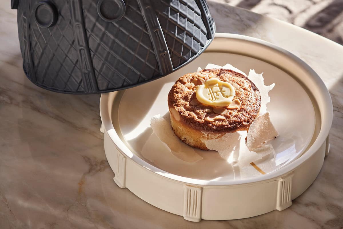 A decorative lantern with a lid and a plate with a pastry.