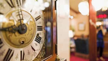 Un primo piano di un orologio vintage con numeri romani e decorazioni elaborate.