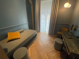 A room with a sofa, a dining table, and a chair.